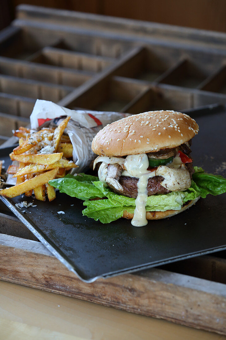 A burger with mushrooms, mayonnaise and chips