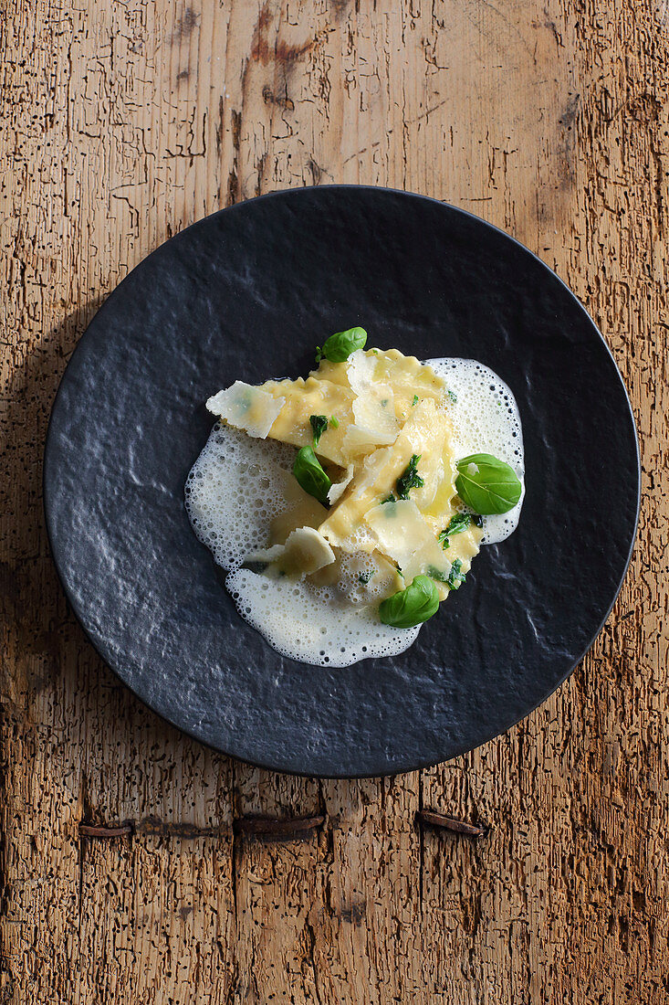 Ravioli with a bread dumpling filling on Parmesan foam