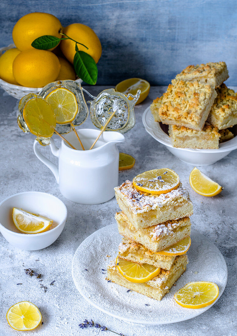Lemon pie cut by squares, decorated with lemon candies and fresh lemons
