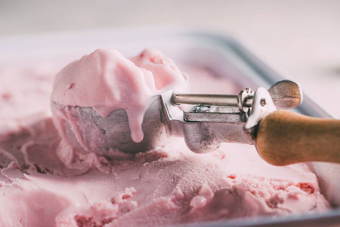 Homemade raspberry ice cream with an ice cream scoop
