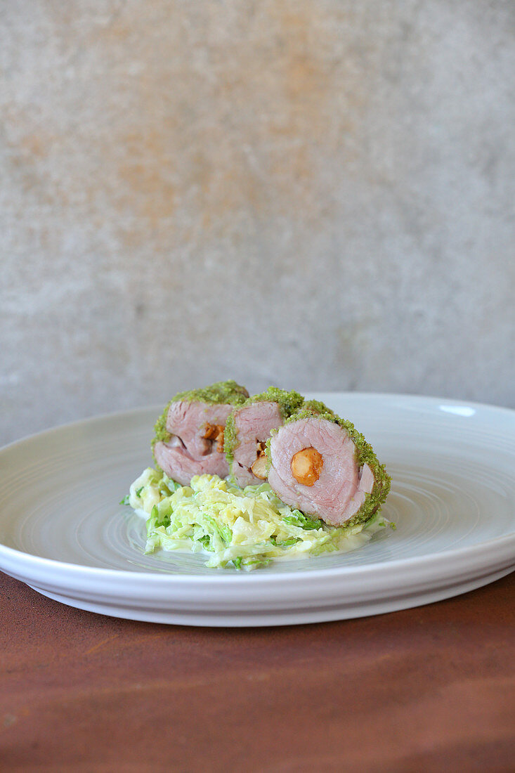 Stuffed pork fillet with a herb crust on a savoy cabbage medley