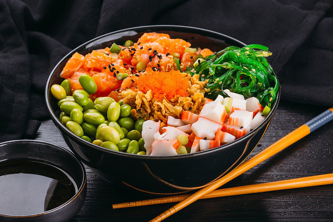 Poke Bowl mit Lachs, Surimi, Edamame und Algen (Asien)