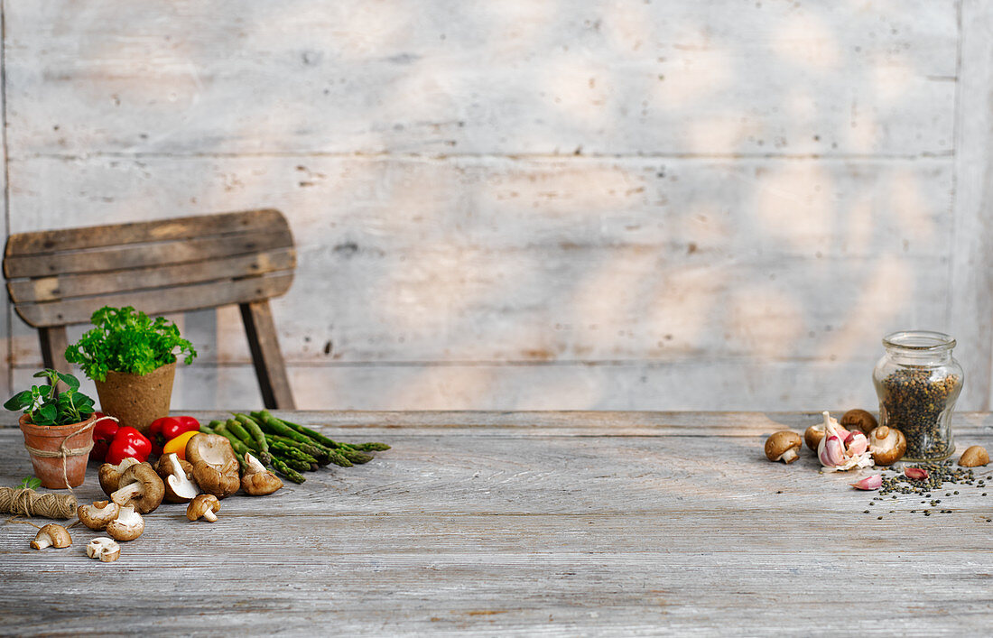 A vegetable still life with herbs on a wooden table