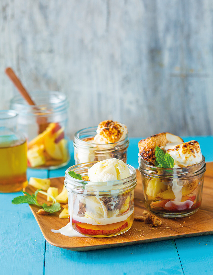 Ananas und Pfirsiche mit Marshmallows und Eiscreme in Gläsern