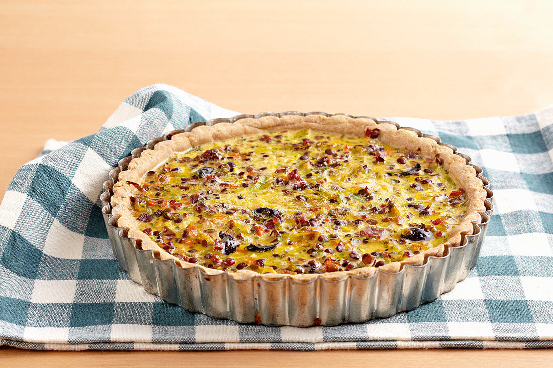 Roman lentil tart with shortcrust pastry, leeks, carrots, bacon, olives and egg