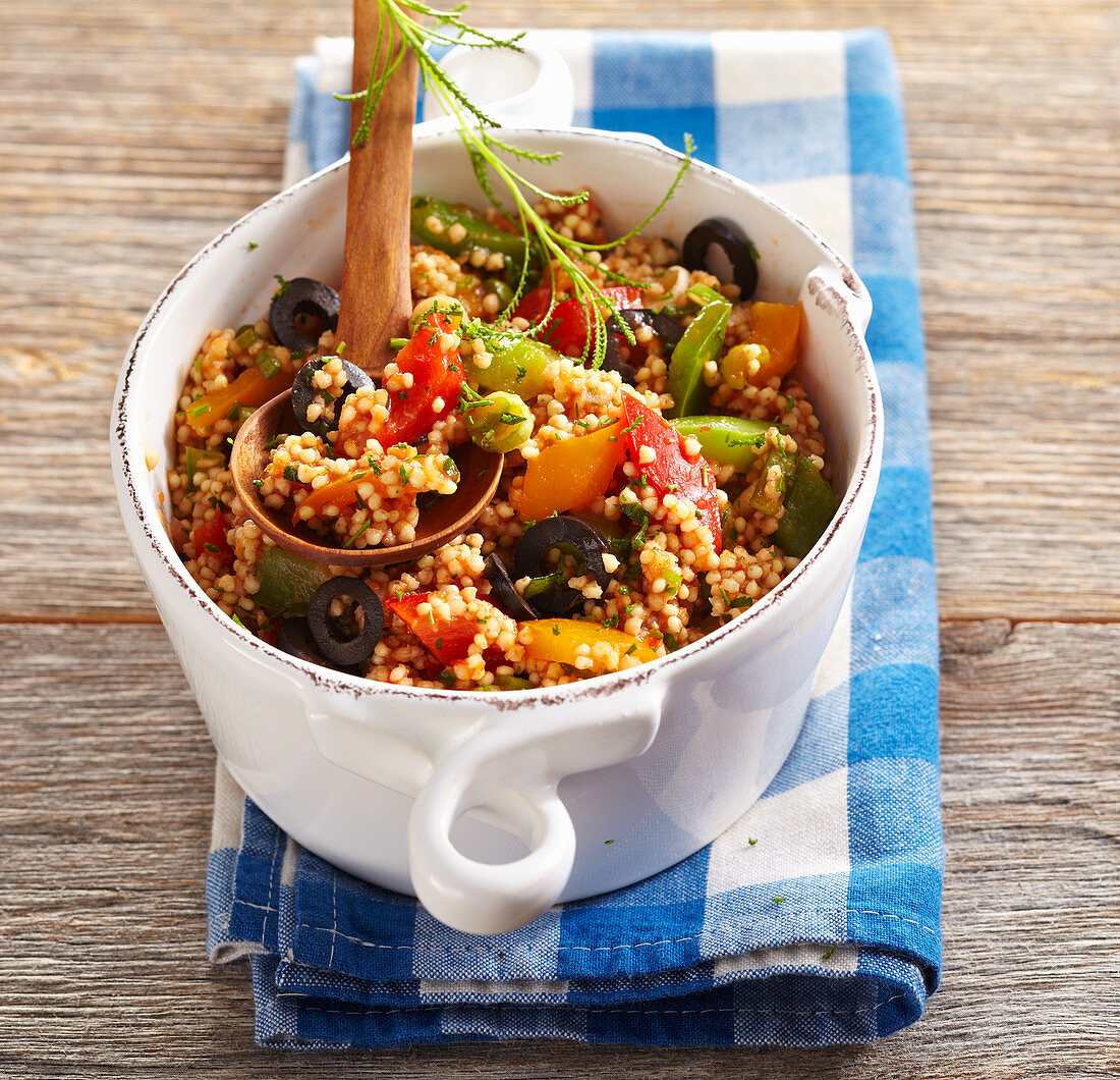 Lukewarm millet and pepper salad with olives and tomato dressing
