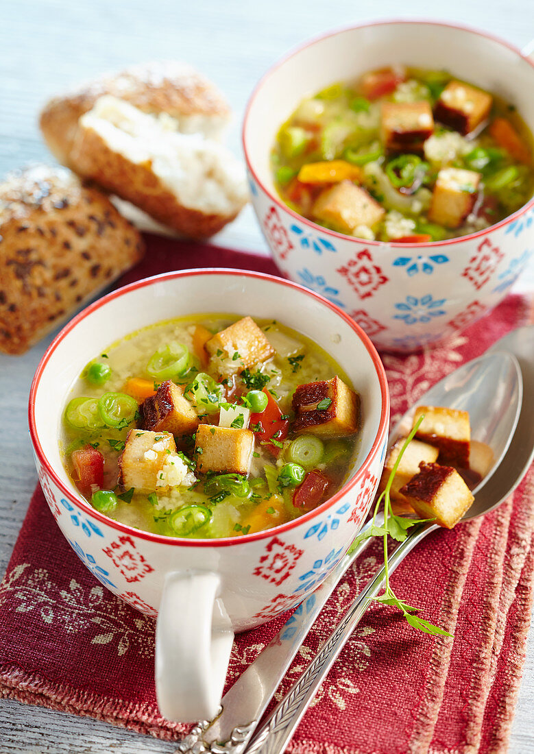 Gemüse-Hirsesuppe mit Räuchertofu serviert in Tassen