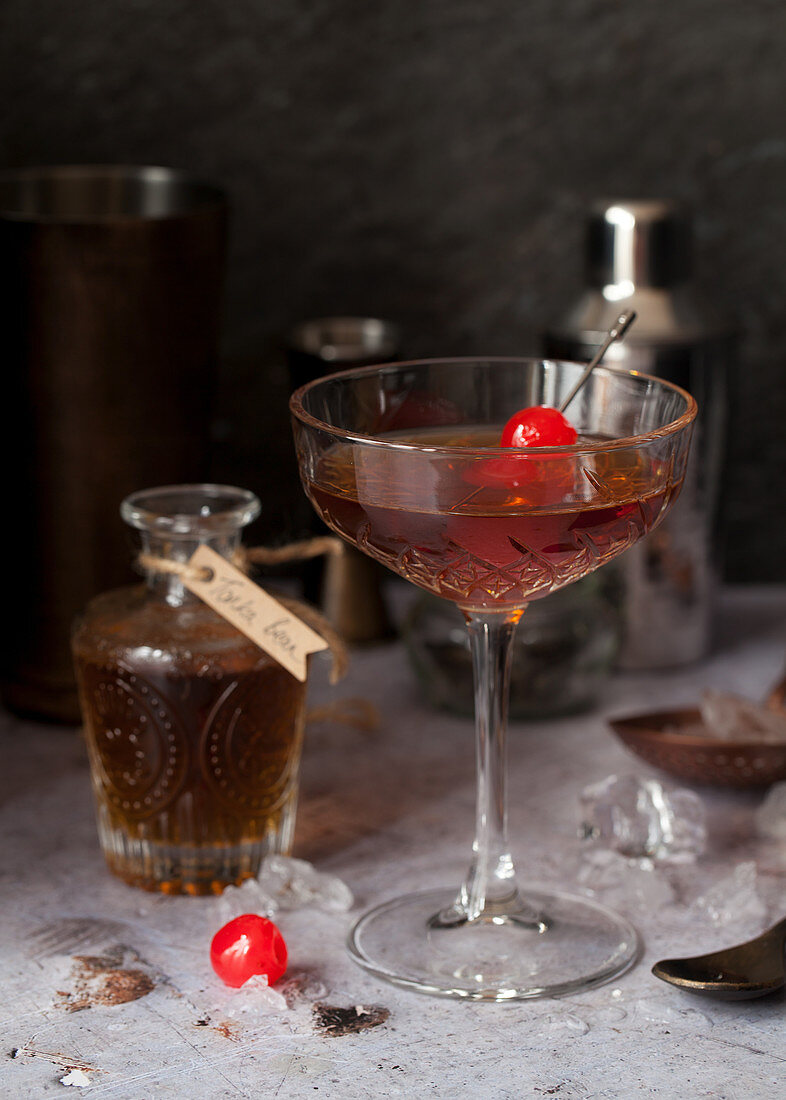 Manhattan-Cocktail mit Tonkabohnensirup und Maraschinokirschen