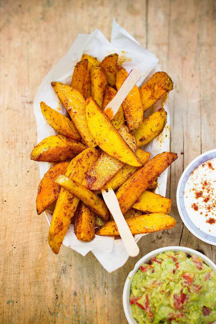 Potato wedges with an avocado dip and a sour cream dip