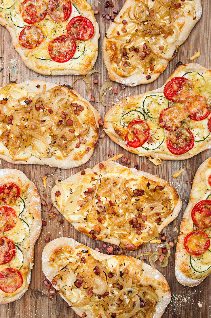 Various tarte flambée on a wooden background (top view)