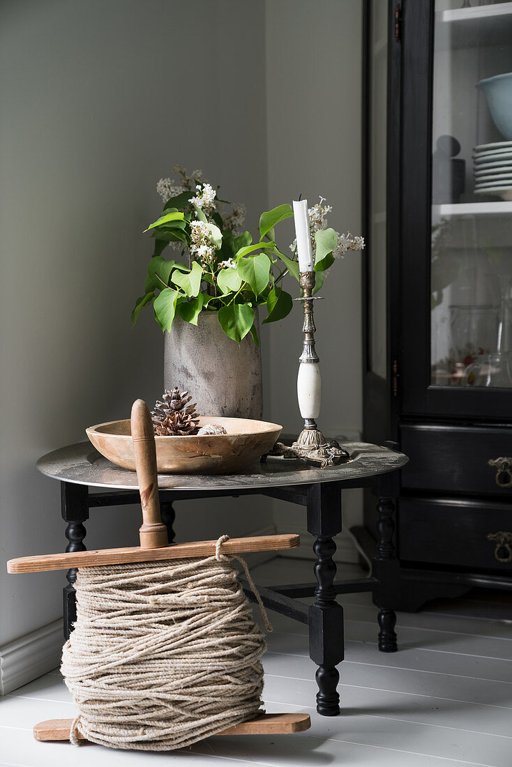 Old wooden reel of yarn in front of Oriental tray table