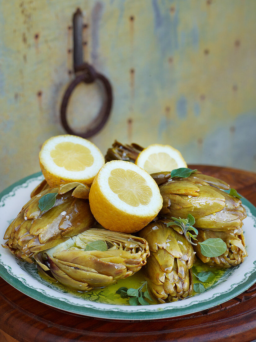 Artichokes with herbs and halved lemons