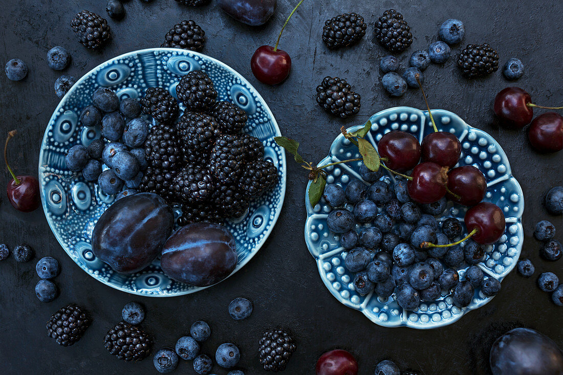Various fruits on blue ceramic plates