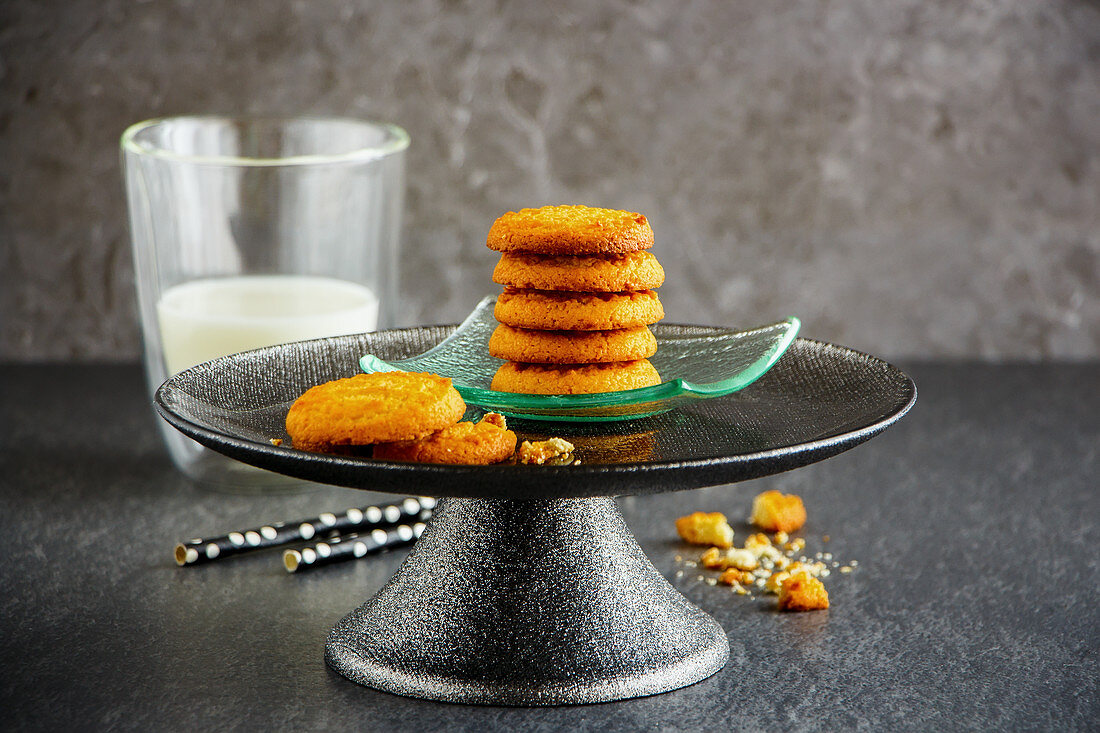 Delicious homemade butter cookies on cake stand and glass of milk
