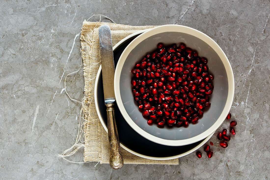 Organic ripe pomegranate fruit in bowl and knife