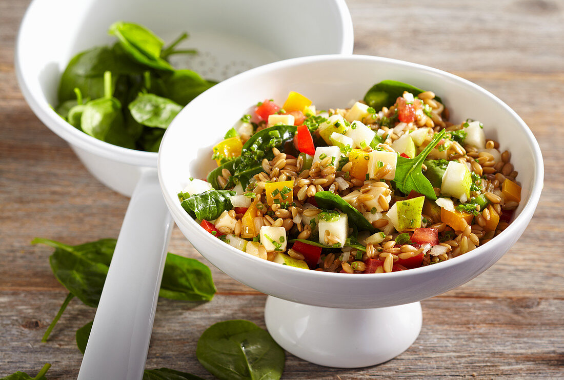 Vegetarischer Paprika-Grünkern-Salat mit Blattspinat, Käse, Gemüse, Birnen und Vinaigrette