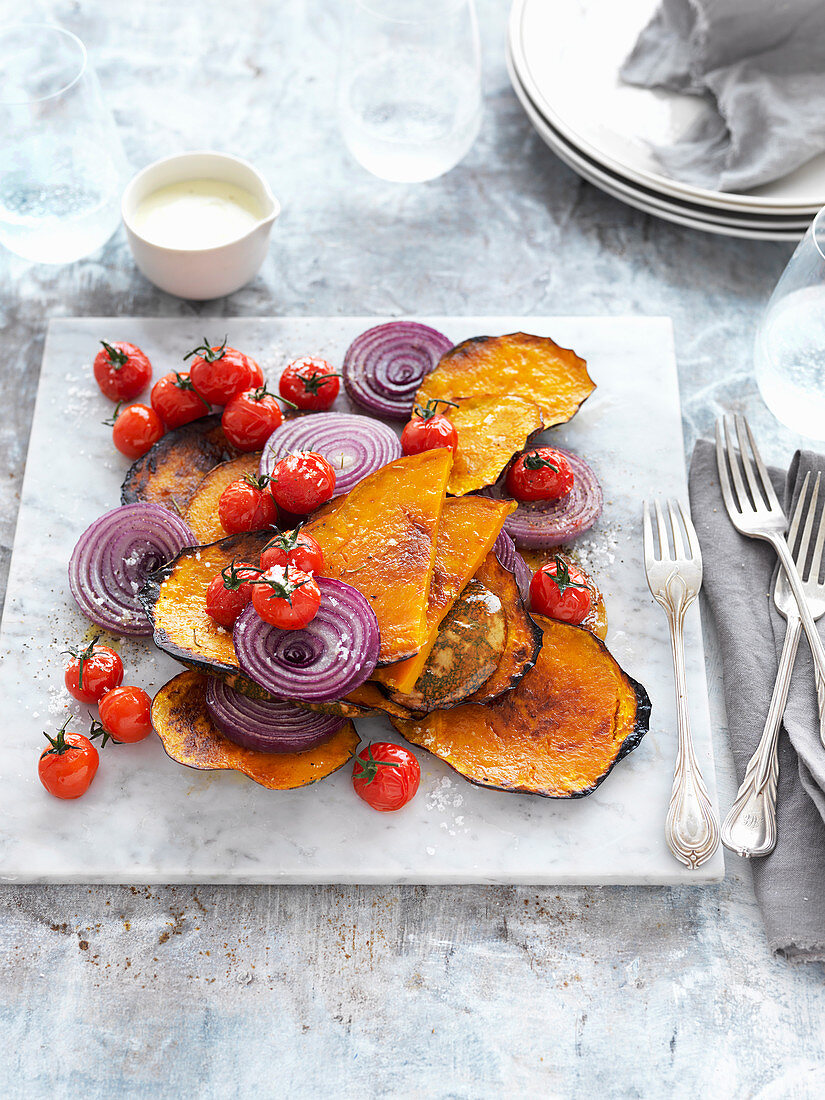 Gebratener Kürbis mit Kirschtomaten, roten Zwiebeln und pikantem Joghurt