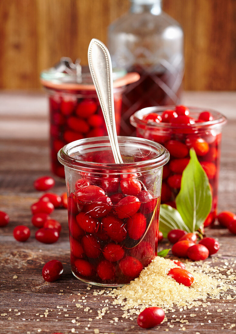 Preserved cornelian cherries in almond liqueur and rum in mason jars