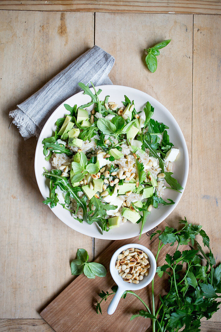 Rice salad with herbs, avocado, feta cheese and pine nuts