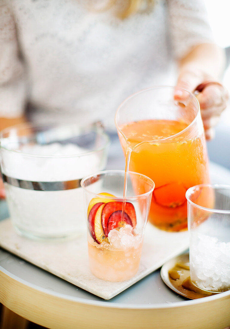 Fruchtiger Gin Spritzer wird aus Karaffe in Gläser gegossen