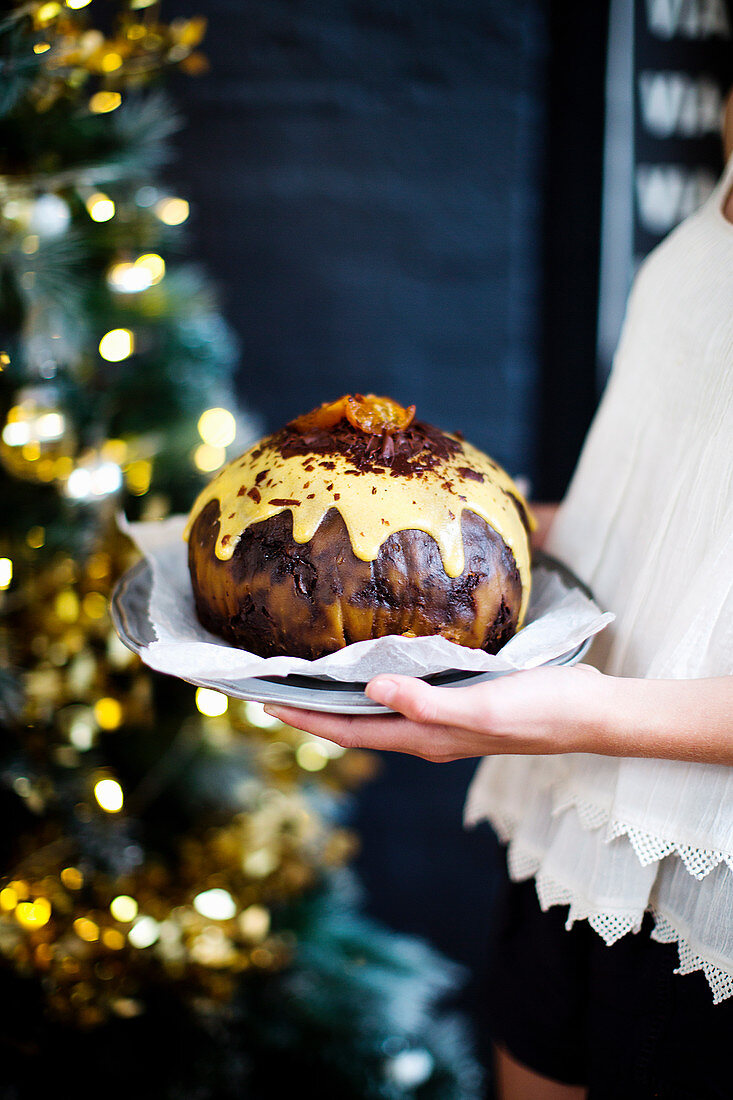 Frau serviert Fudgy Jaffa Pudding auf Silberteller (Weihnachten)