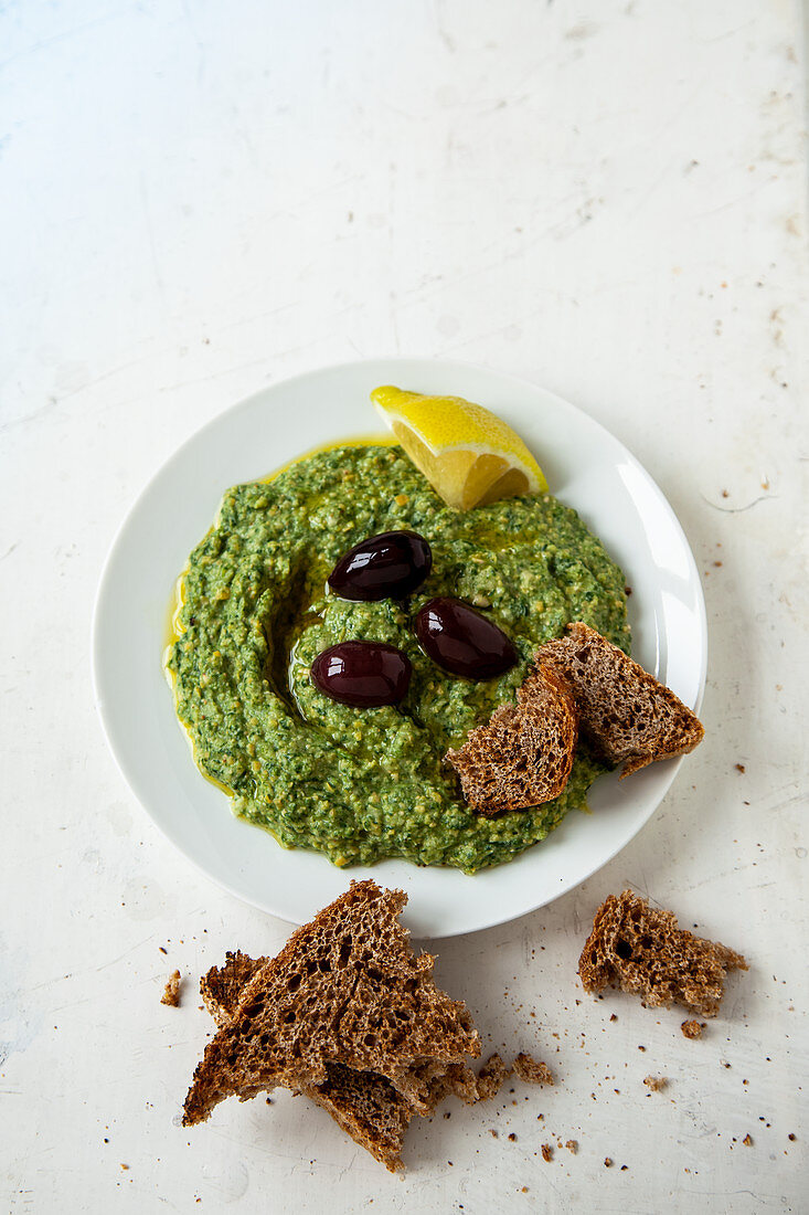 Spinathummus mit schwarzen Oliven und Brot