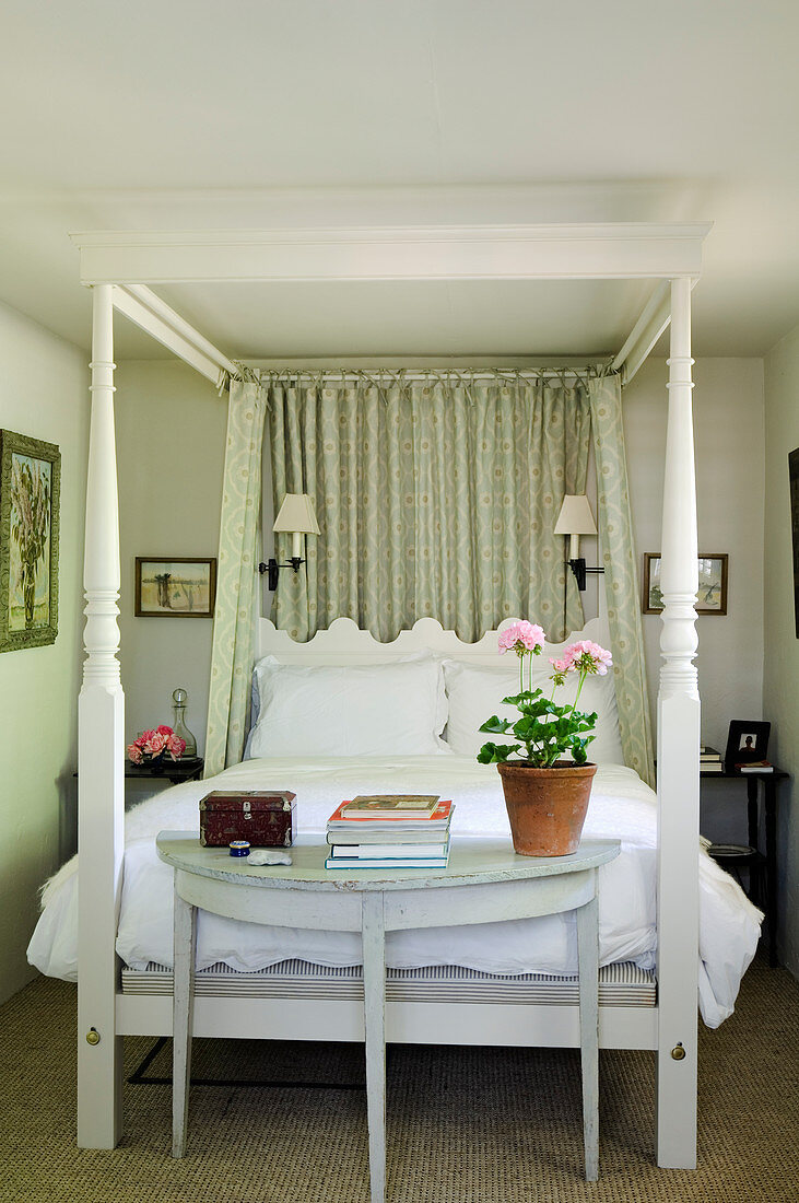 Antique four-poster bed in small bedroom of period villa