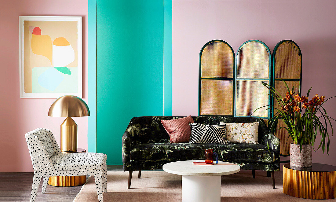 Chair, sofa, side tables and screen against pink and green wall in living room