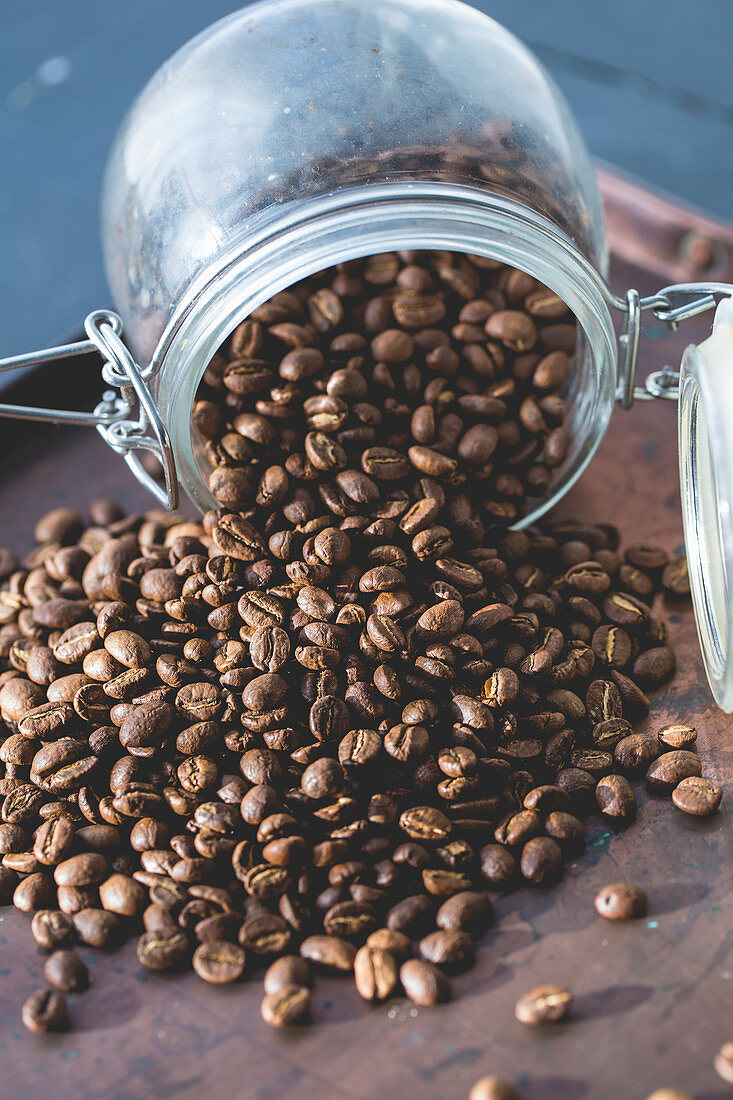 Coffee beans falling out a glass