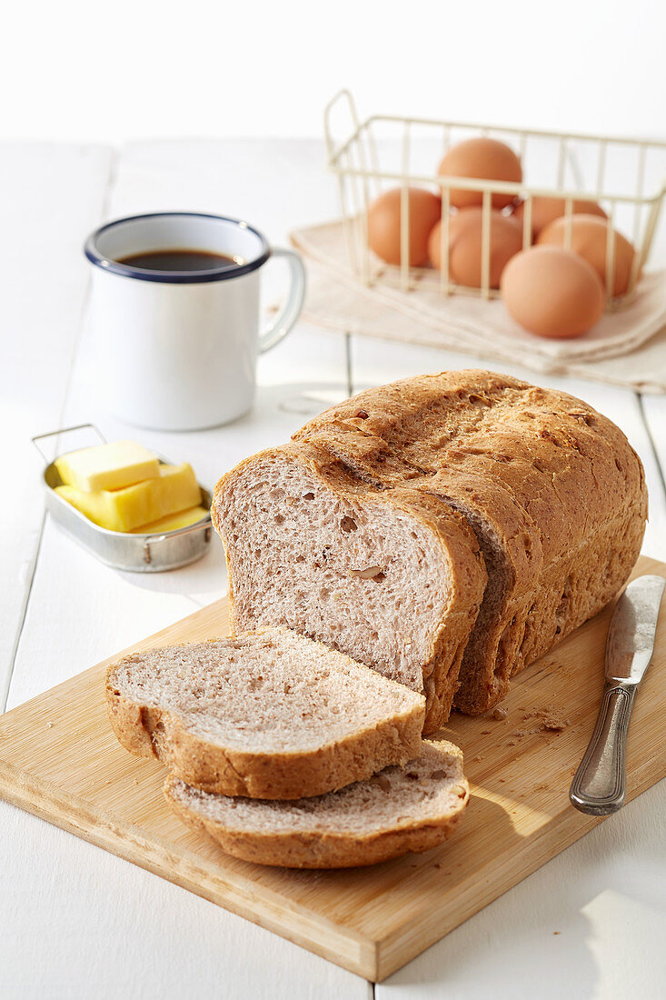 Angeschnittenes Brot mit schwarzem Kaffee, Butter und Eiern