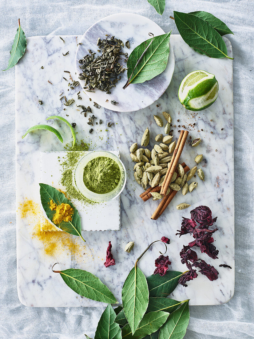 A still life with spices, lime, matcha powder and tea