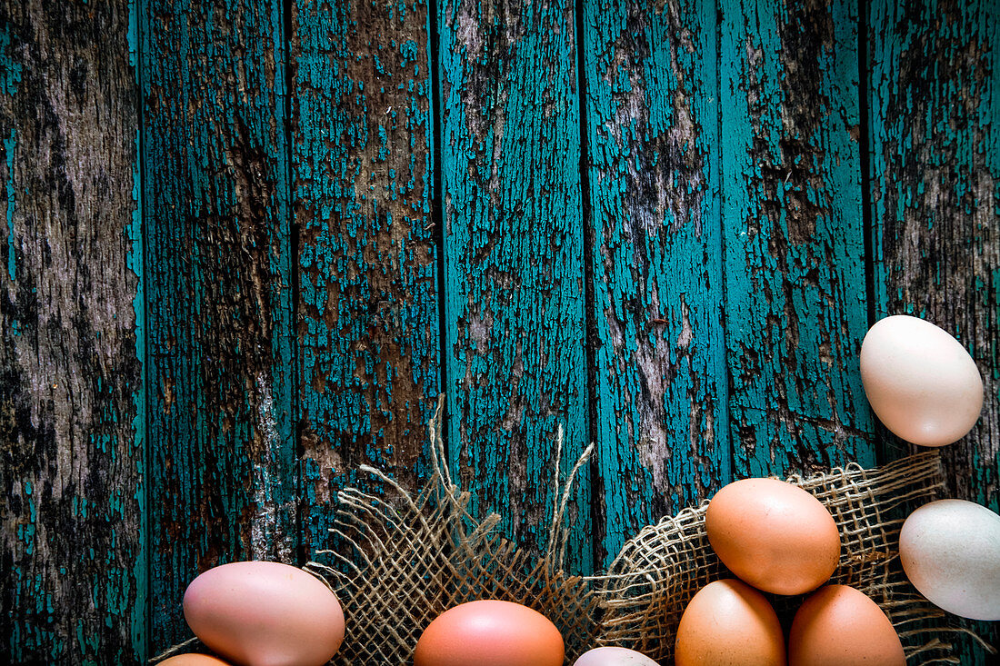 Hühnereier auf blauem Holzuntergrund