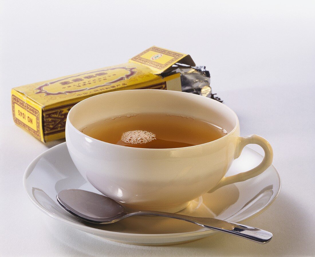 Eine Tasse schwarzer Tee & Teepäckchen aus China