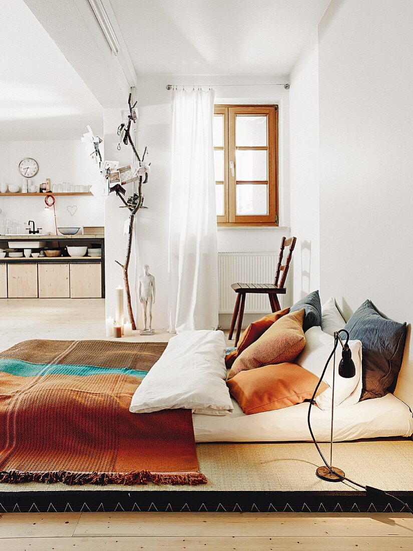 A sleeping area with tatami mats and cushions