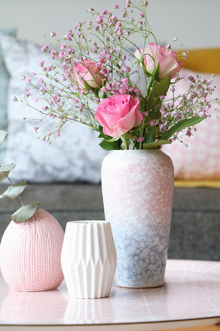 Rosen und rosafarbenes Schleierkraut in gesprenkelter Vase