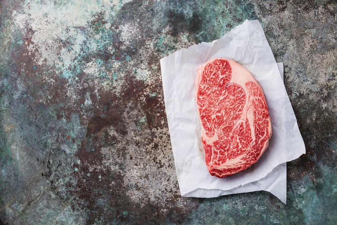 Rohes Ribeye Steak vom Angusrind auf Metalluntergrund