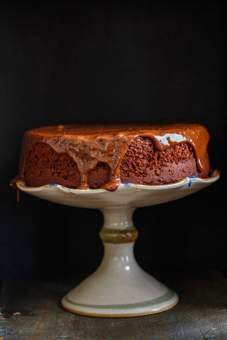 Eifreier Schokoladenkuchen mit Milchschokoladen-Ganache auf einem Kuchenständer