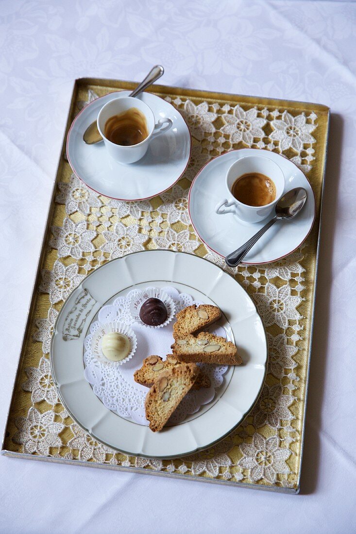 Espresso, Cantuccini und Pralinen auf Tablett