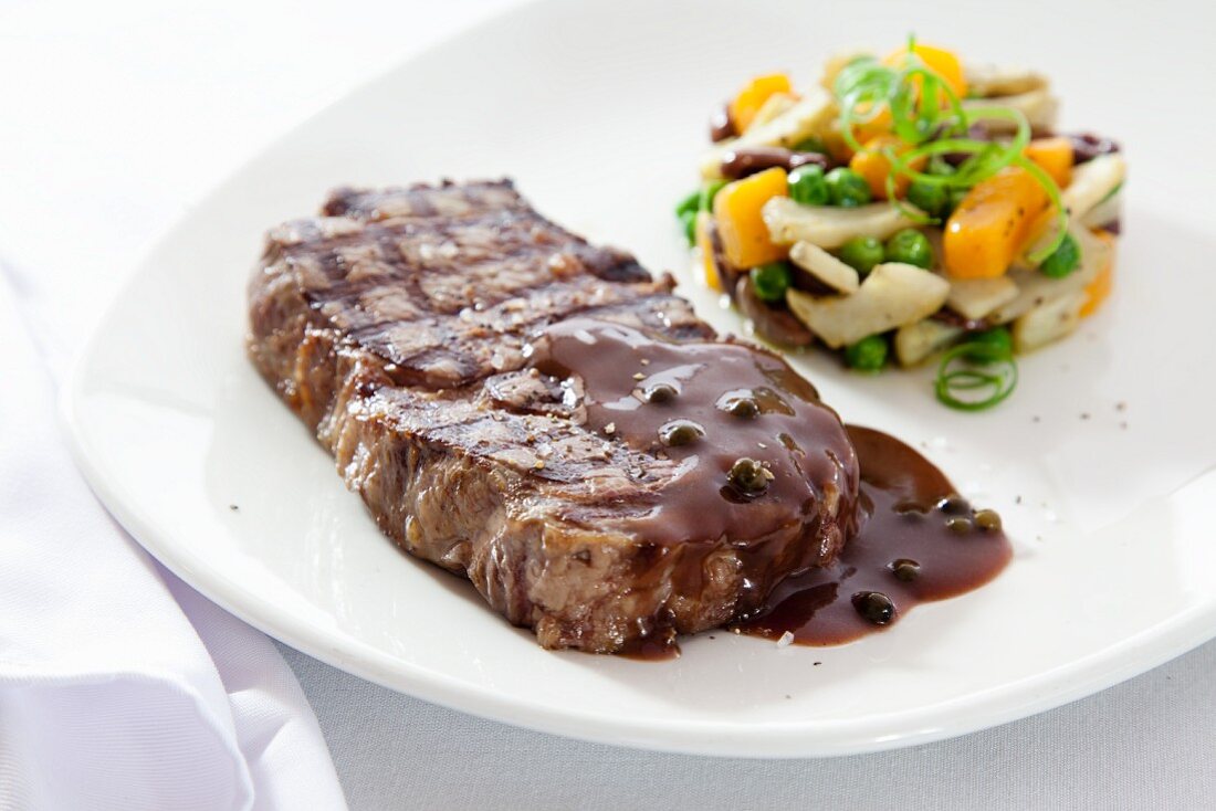 Beef steak with pepper sauce and vegetable timbale