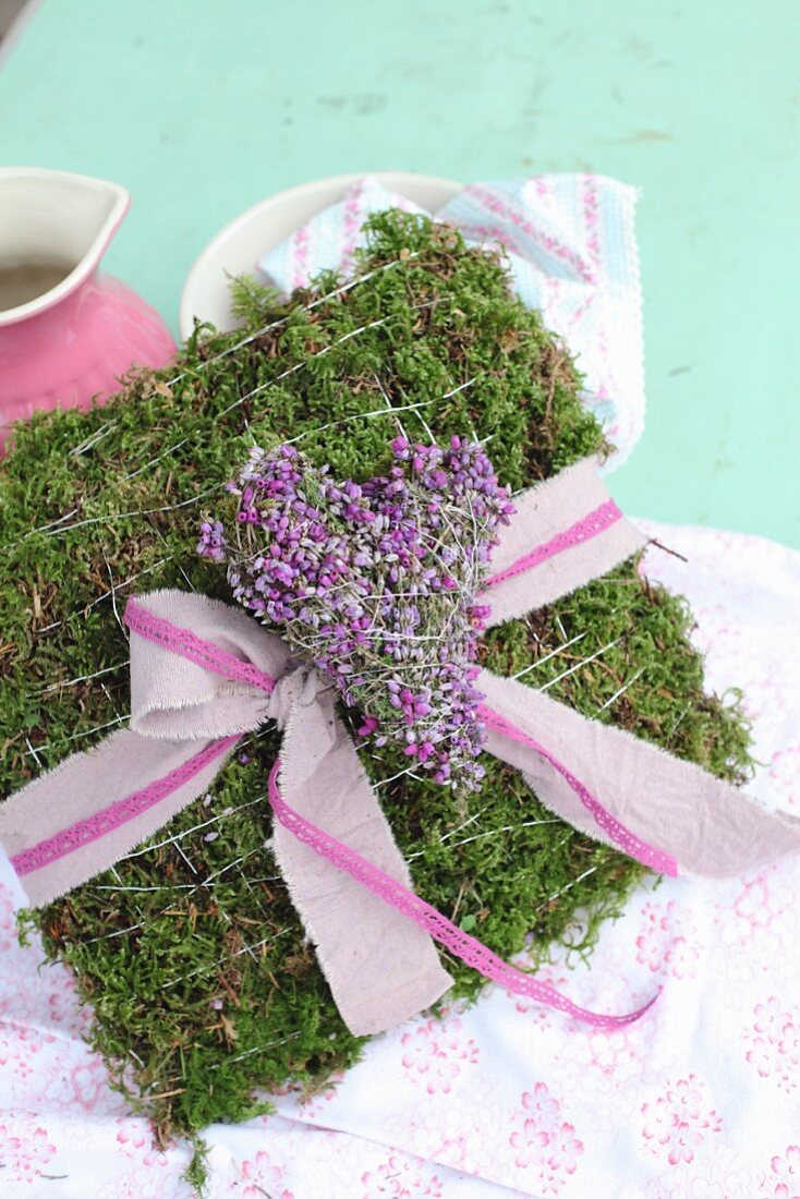 Pink ribbon and heather love-heart on romantic moss cushion