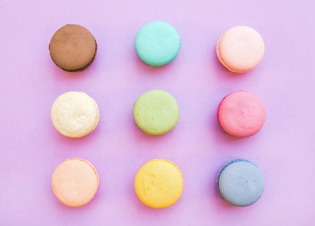 Sweet colorful French macaron biscuits on pastel pink background