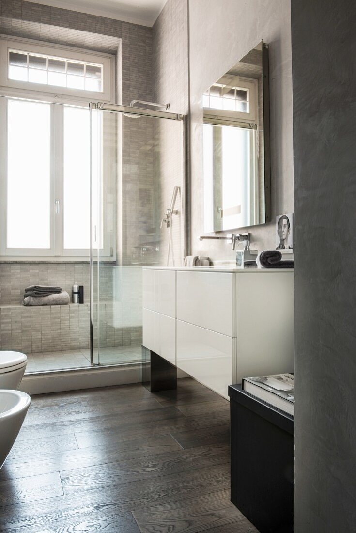 Shower next to window in modern bathroom in shades of grey