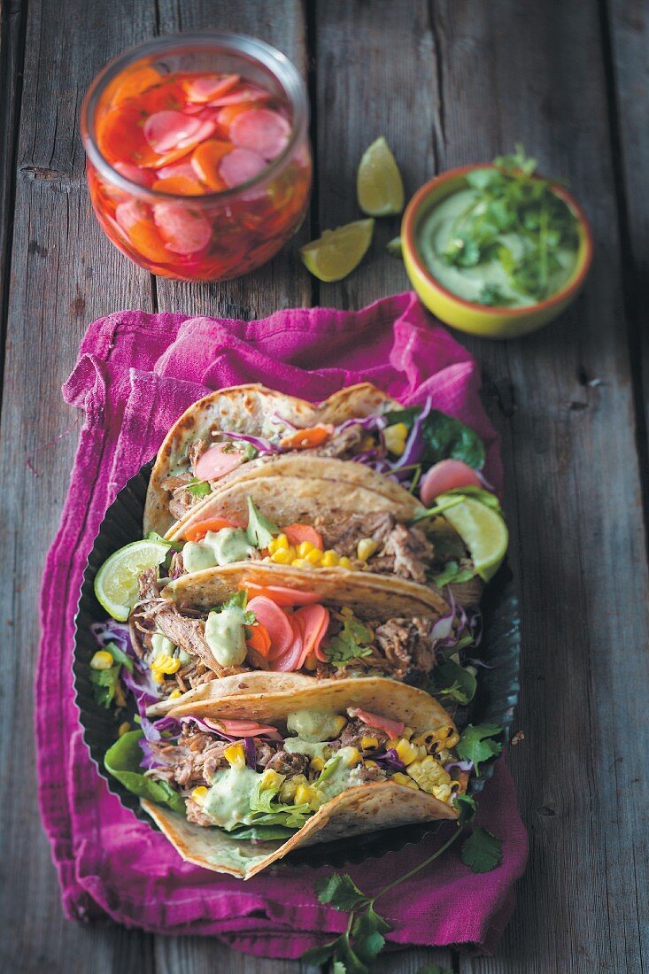 Tacos with pork, fermented vegetables and an avocado and coriander sauce