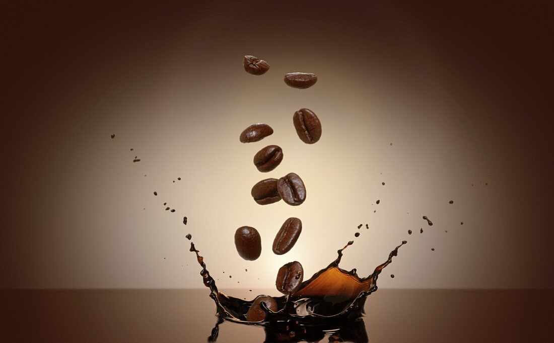 Kaffeebohnen fallen in Kaffee