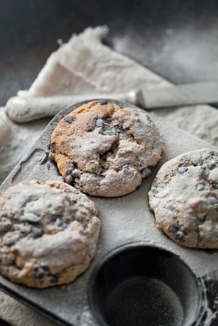 Vegane Bananemuffins mit Chocolate Chips und Puderzucker in einem Muffinblech