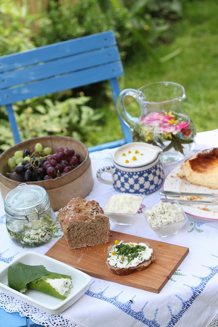 Gedeckter Tisch mit Dinkel-Roggen-Hausbrot, Quarkbällchen, Quarkaufstrich und Käsekuchen