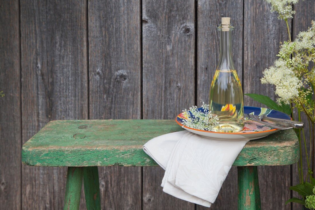 Homemade elderberry blossom oil in a bottle, on a plate