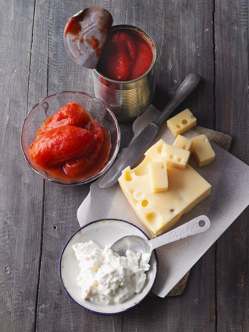 Ingredients for pizza: ricotta, Emmental and tinned tomatoes