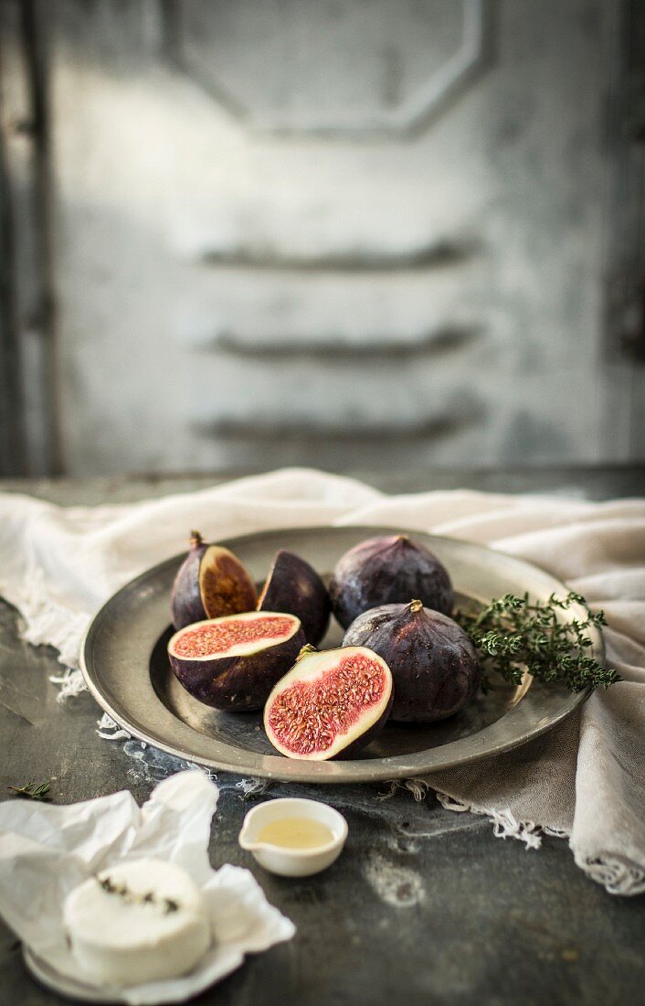 A still life with figs, thyme, goat's cheese and honey