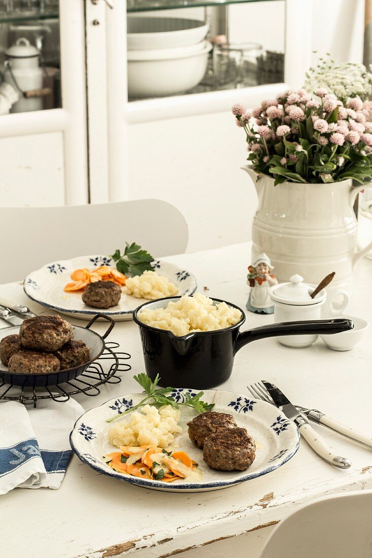 Meatballs with mashed potatoes and carrots on a dining table